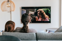 a couple of women sitting on top of a couch