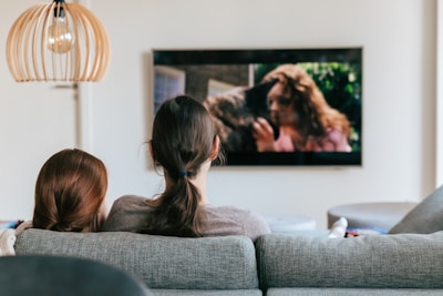 a couple of women sitting on top of a couch