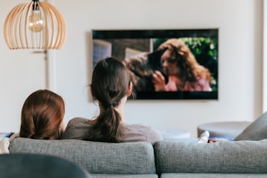 a couple of women sitting on top of a couch