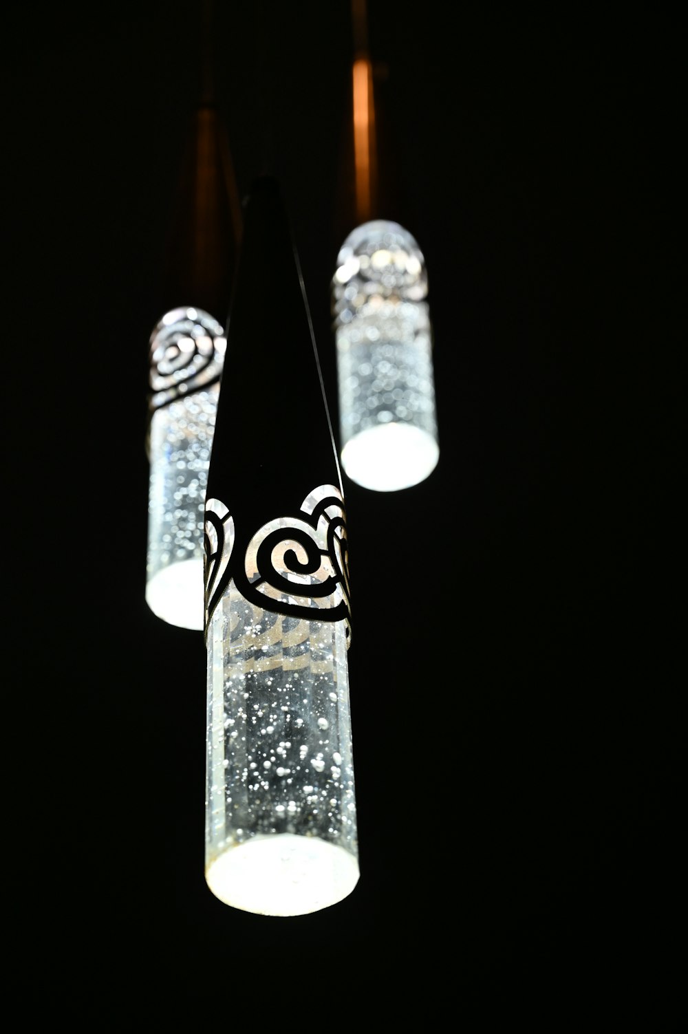 a group of lights hanging from a ceiling in the dark