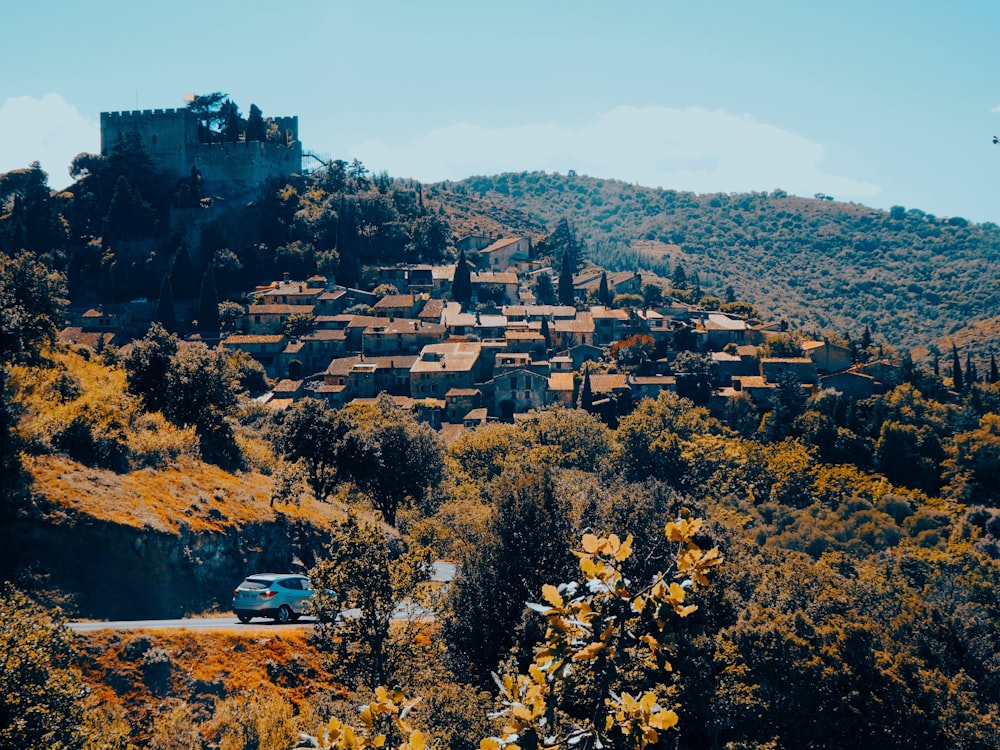 a small village on a hill surrounded by trees