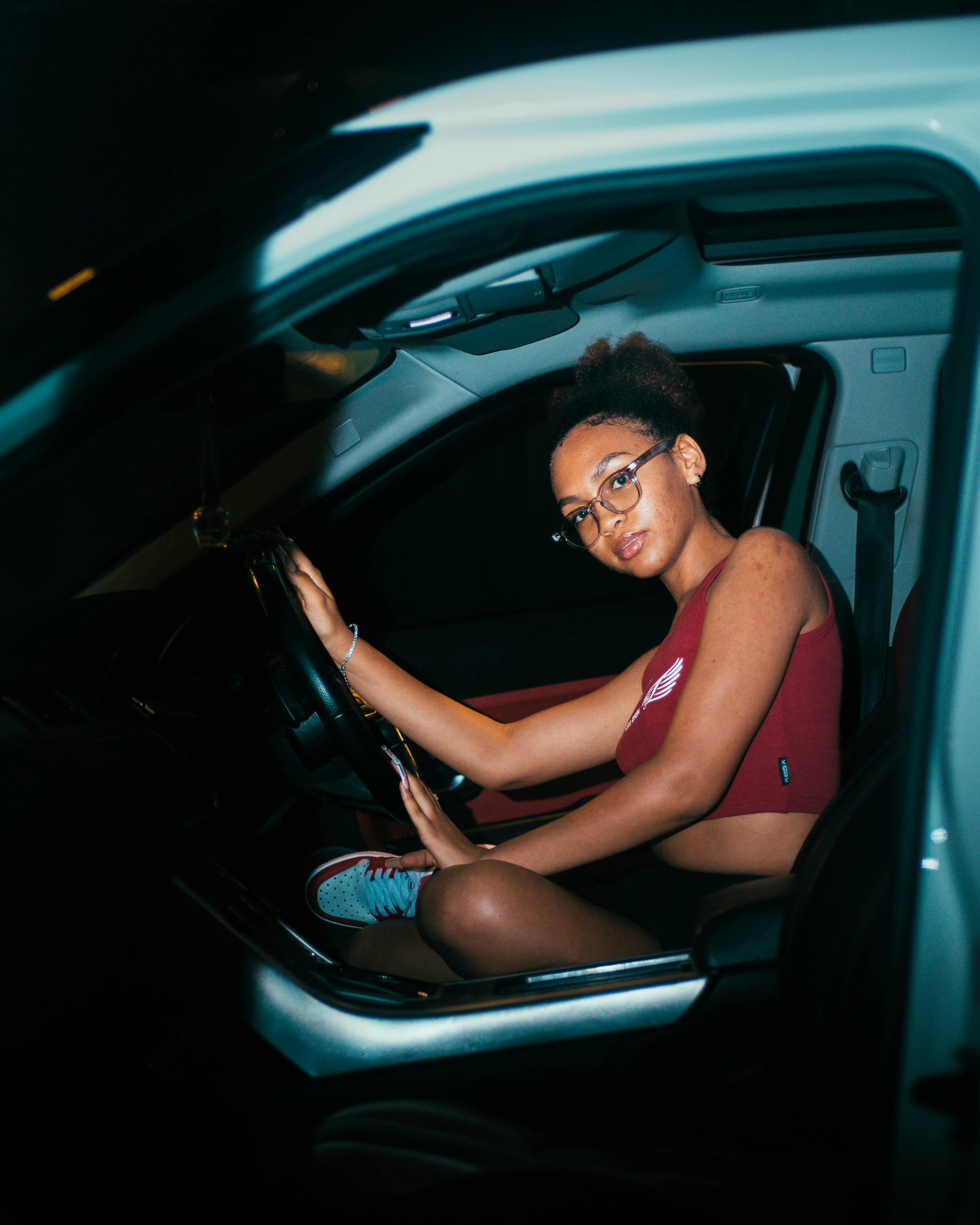 a woman sitting in a car holding a steering wheel