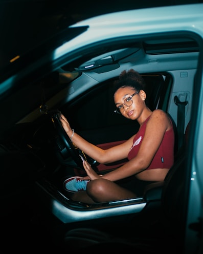 a woman sitting in a car holding a steering wheel