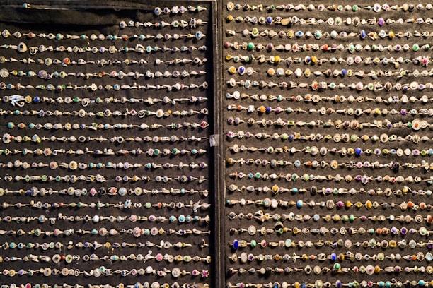 An elegant display of rings featuring different designs and materials on a soft fabric background.