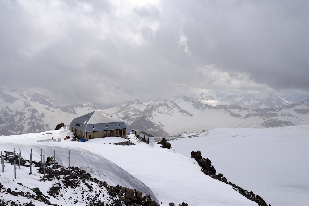 a snow covered mountain with a house on top of it