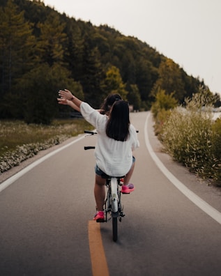 A joyful family bike ride on a tree-lined trail, capturing smiles and motion.