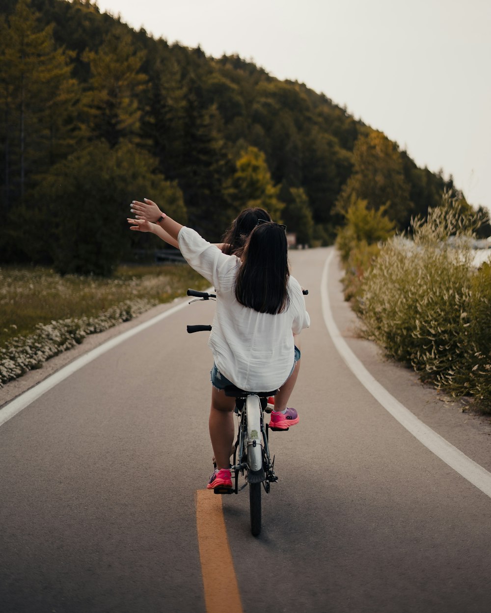 a woman riding a bike down a curvy road