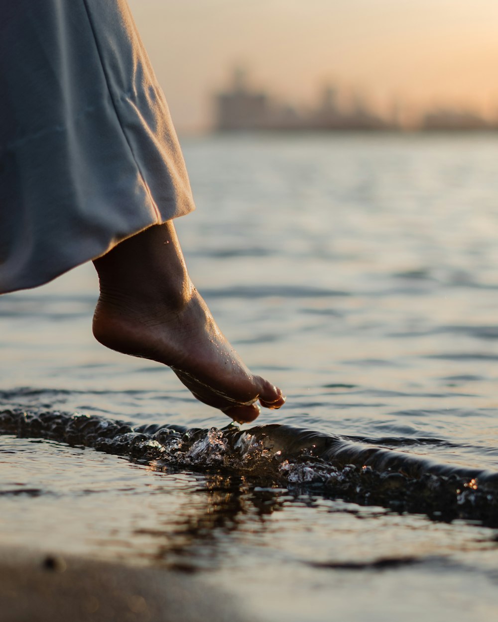 a person standing in the water with their foot in the water