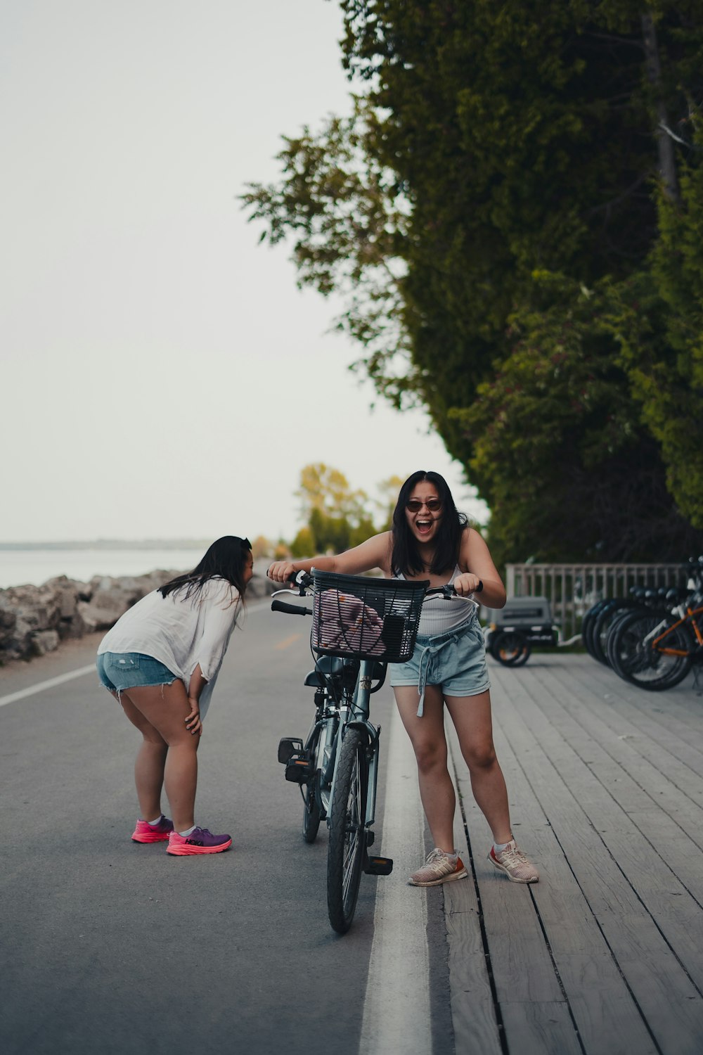 自転車の近くに隣り合って立つ2人の女性