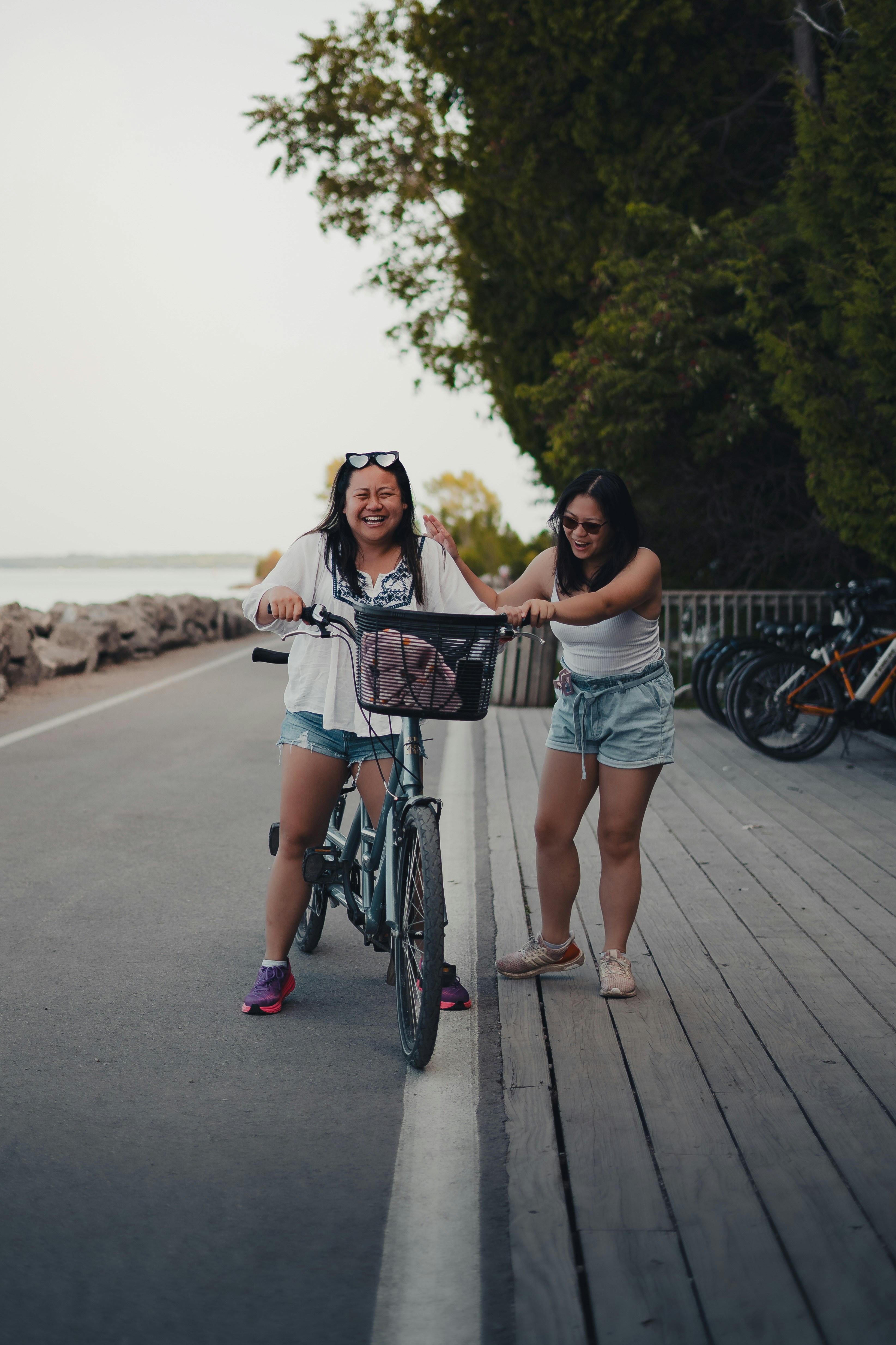 two women standing next to each other on a pier
