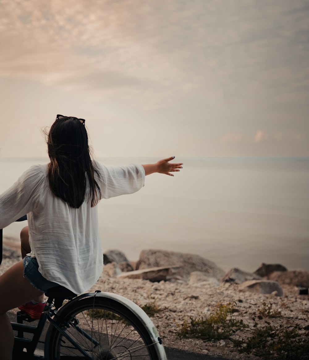 a woman in a wheelchair pointing at the ocean