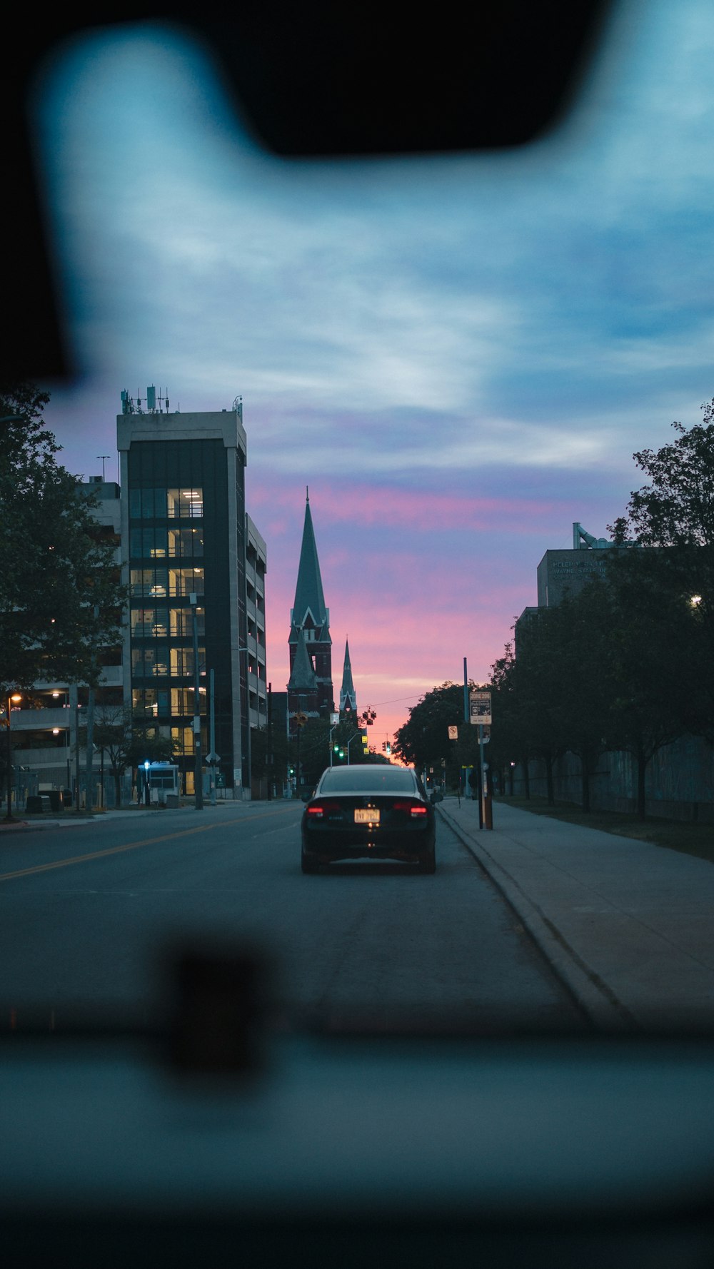 a car driving down a street next to tall buildings