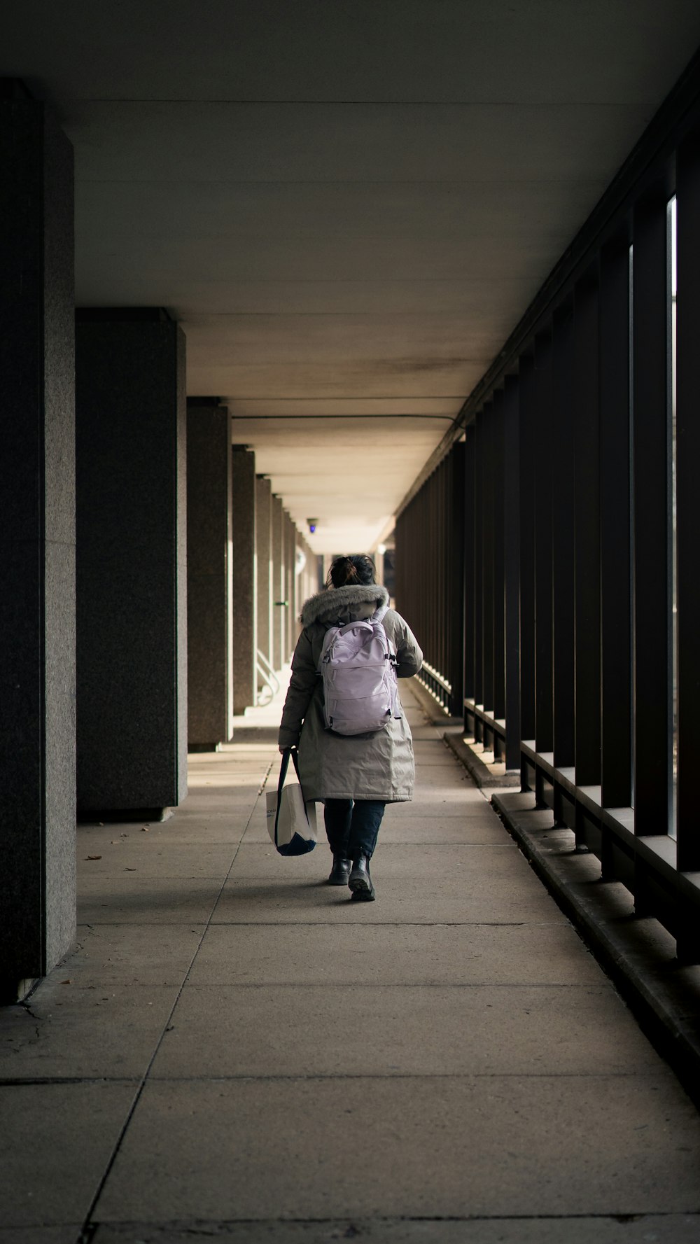 a person walking down a walkway with a backpack