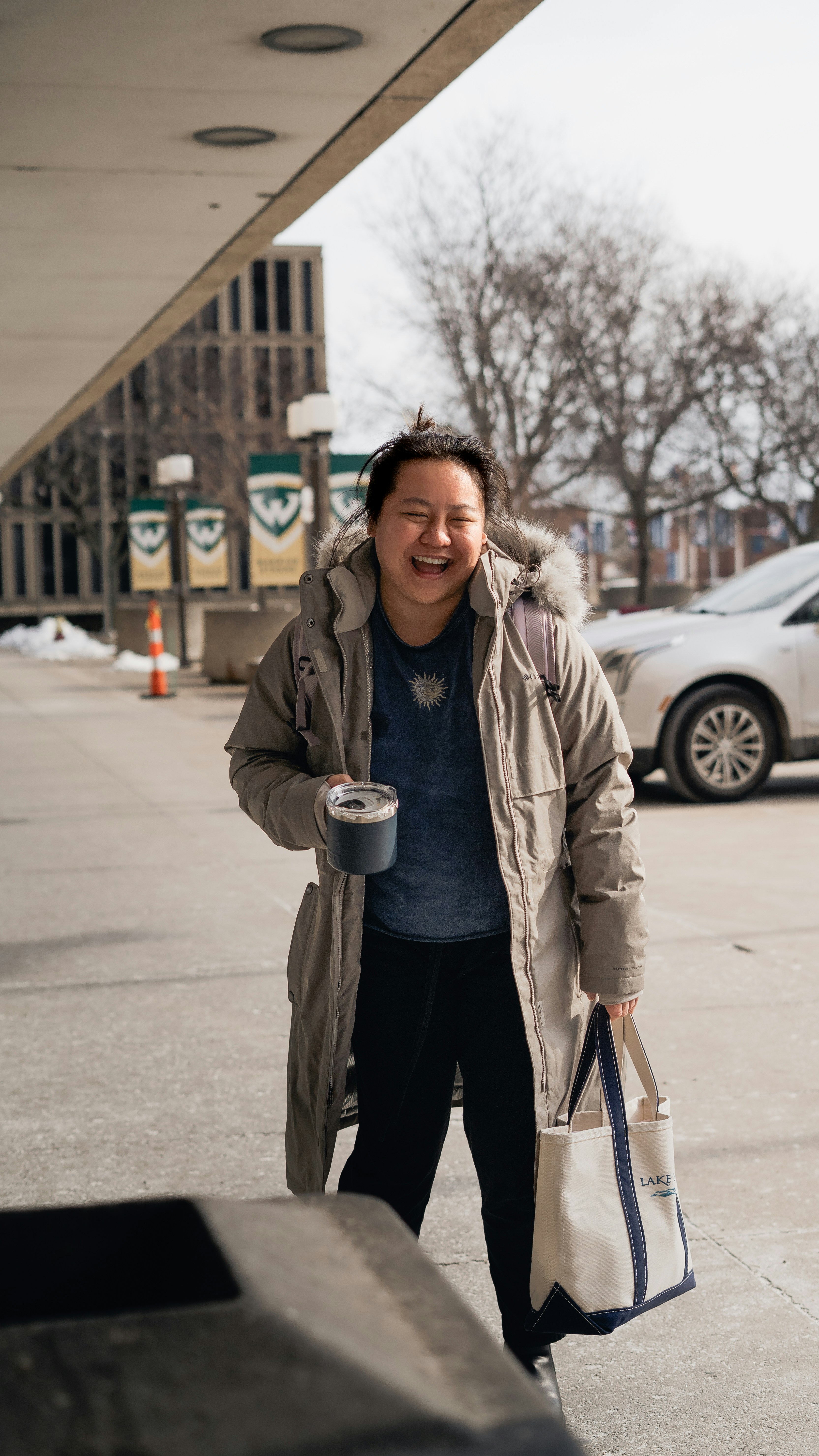 a woman walking down a street holding a cup of coffee