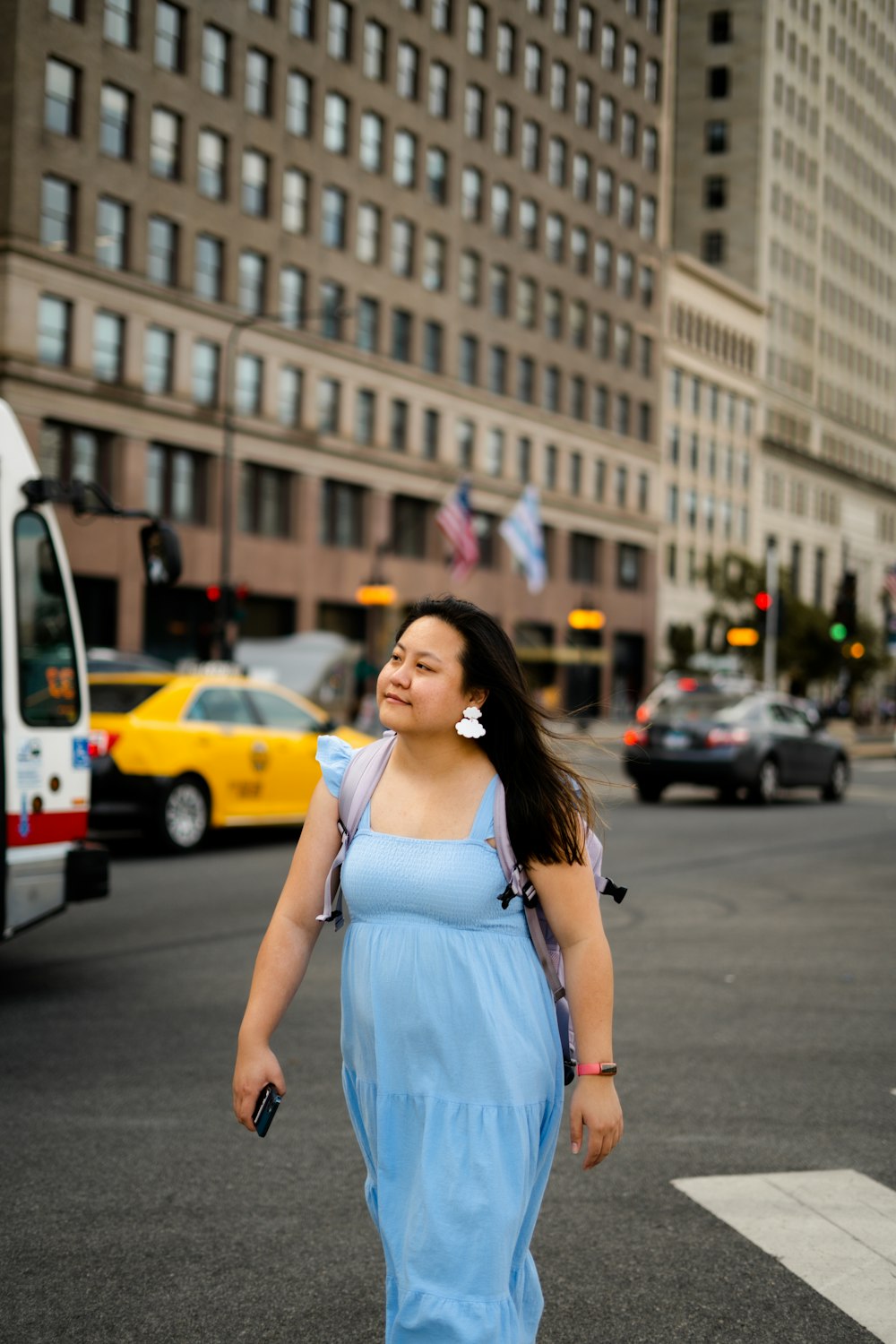 a woman in a blue dress is crossing the street