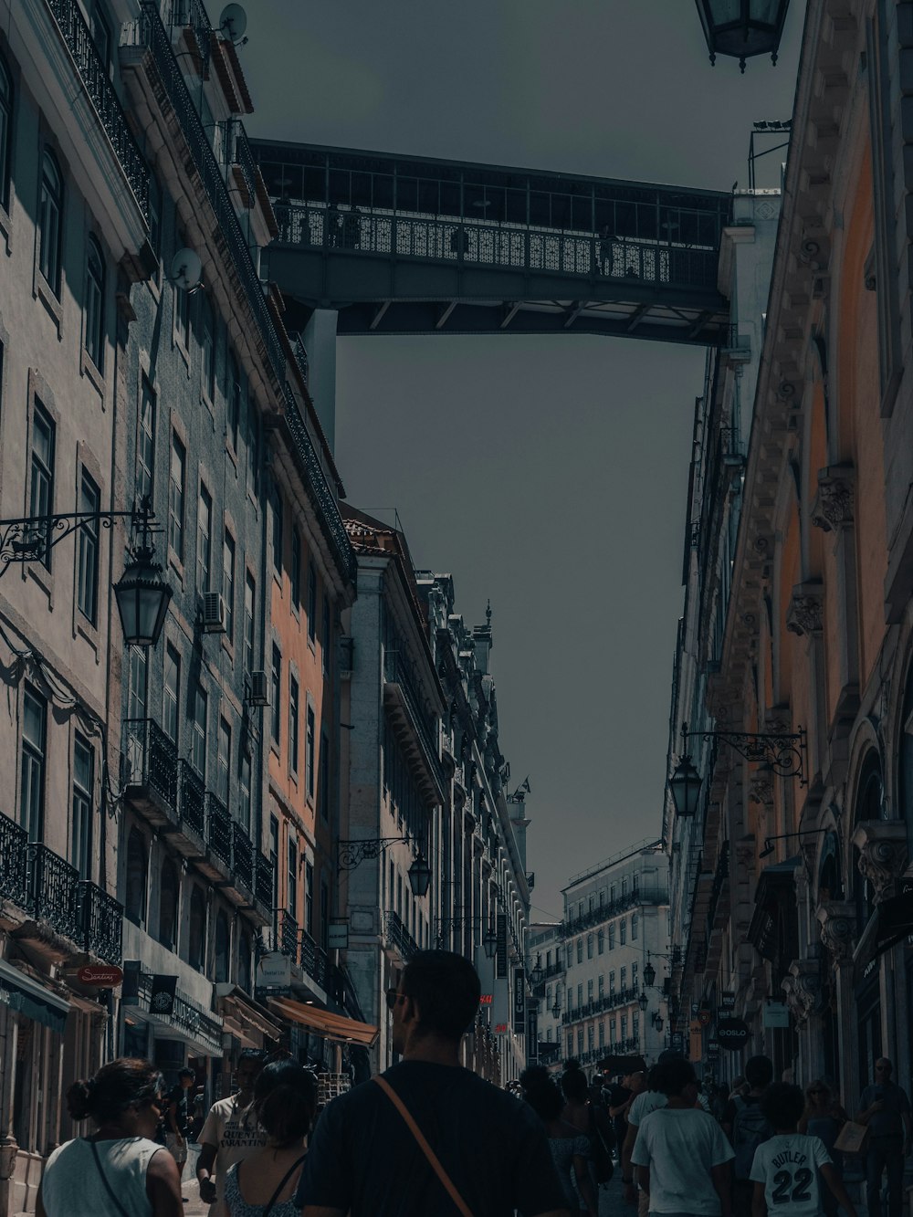 a group of people walking down a street next to tall buildings