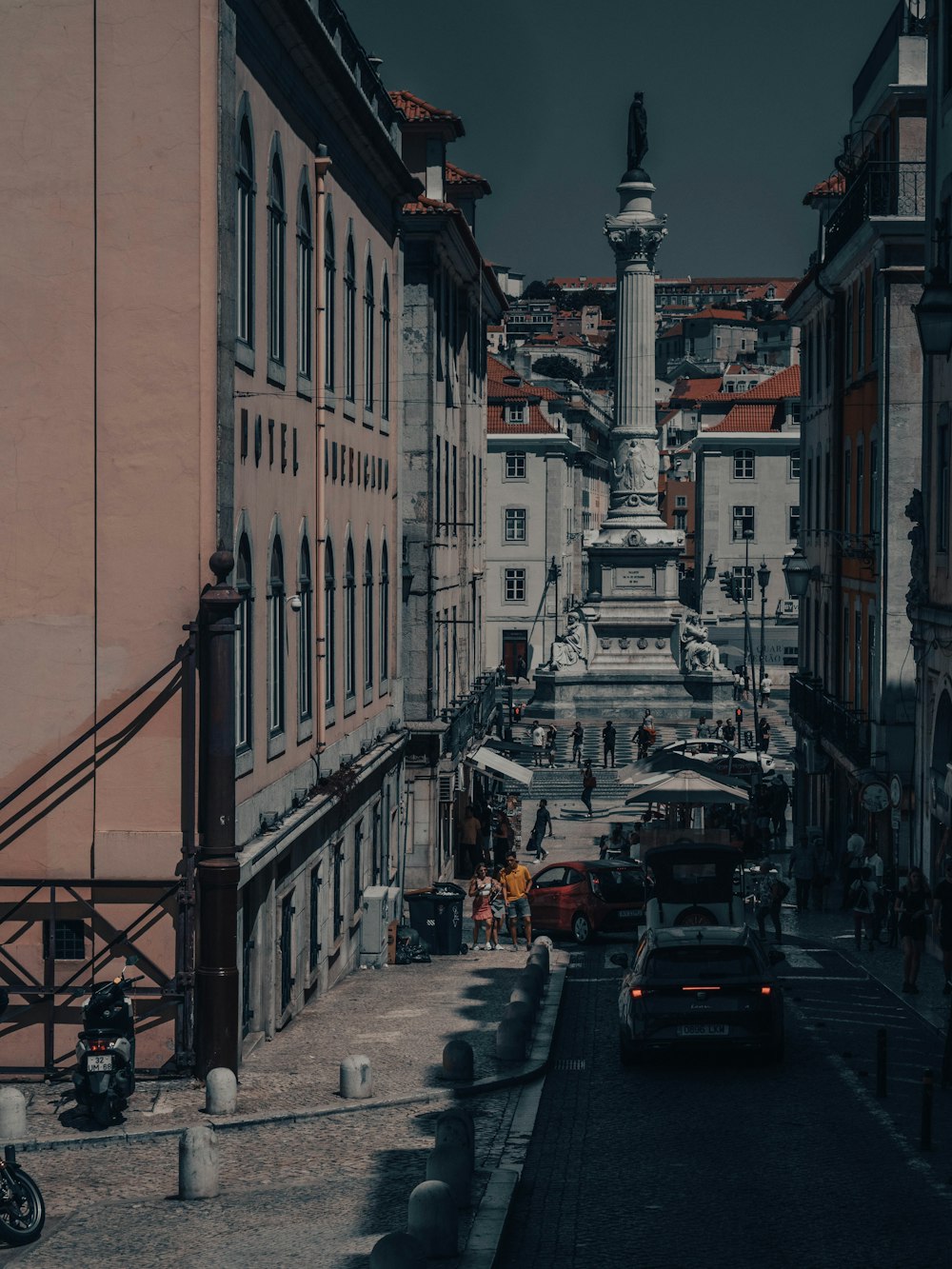 a city street lined with tall buildings under a cloudy sky