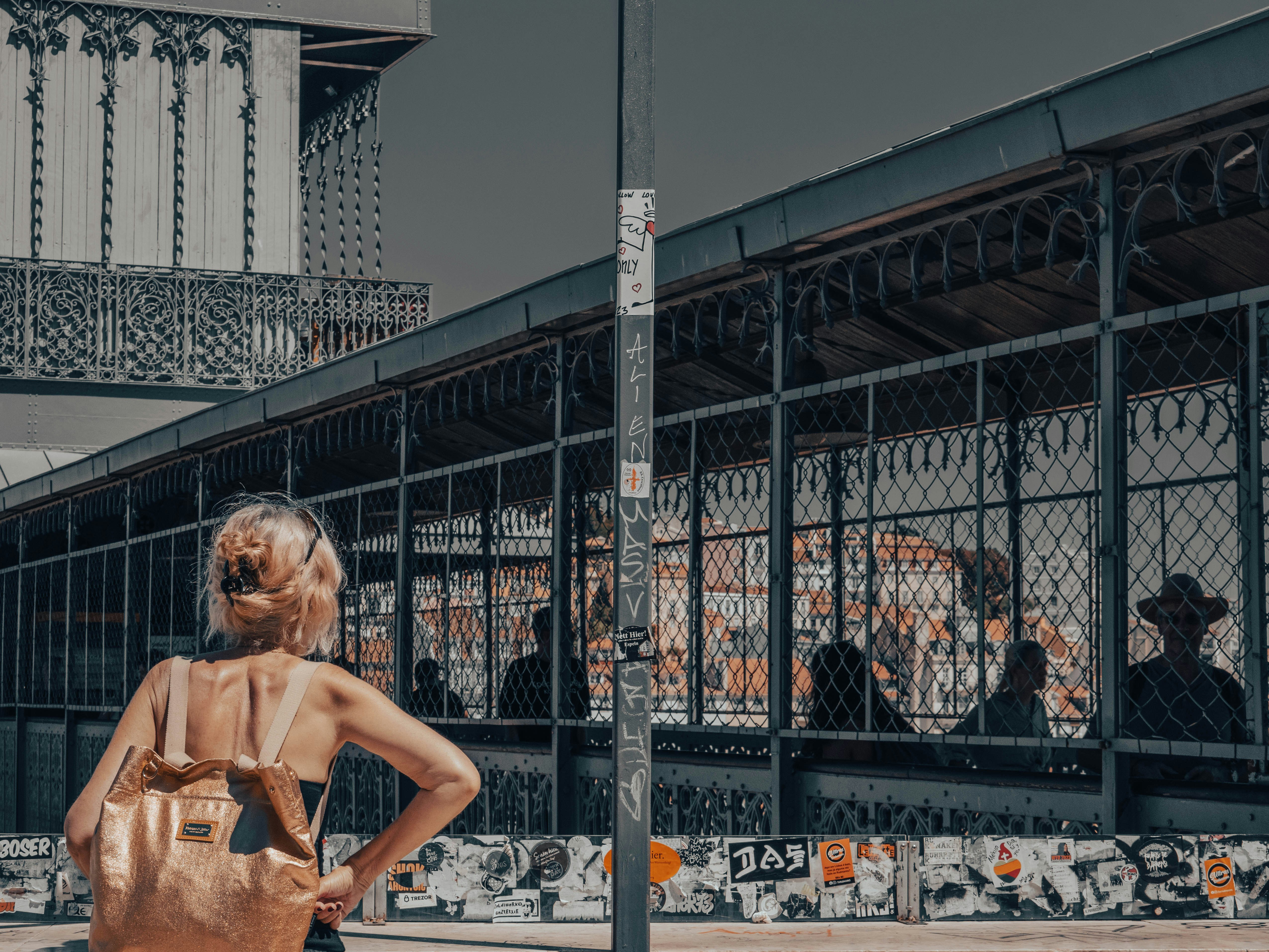 A woman standing on a street corner with her back to the camera photo ...