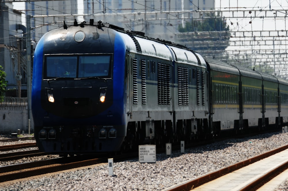 Un treno blu e argento che viaggia lungo i binari del treno