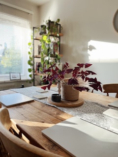A cozy dining table adorned with a textured jute runner and a vase of fresh flowers.