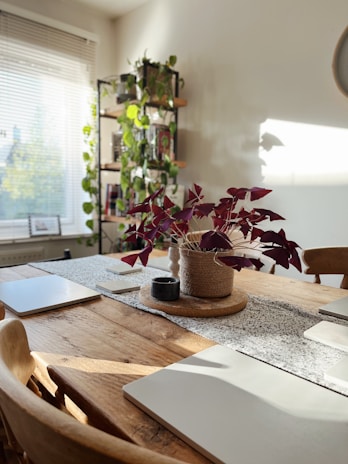 A cozy dining table adorned with a textured jute runner and a vase of fresh flowers.
