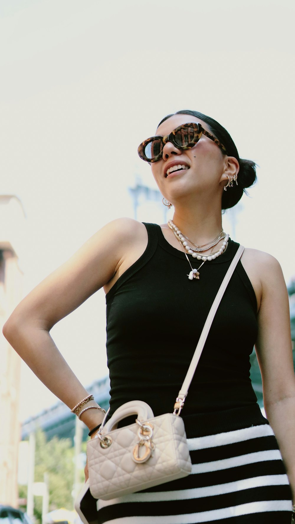 a woman in a black and white dress holding a purse