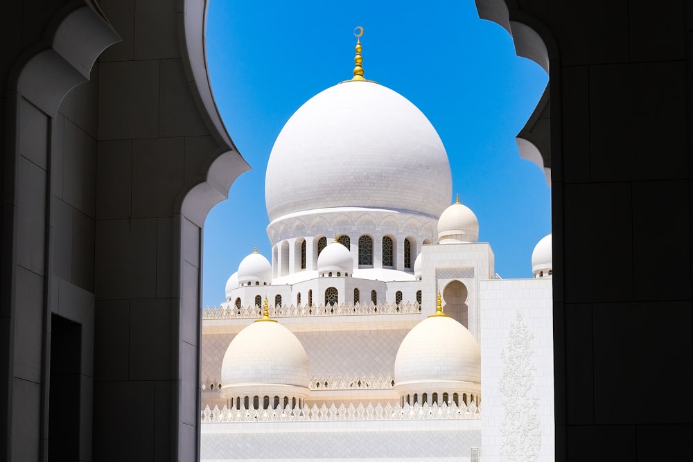 a view of a white building through an archway