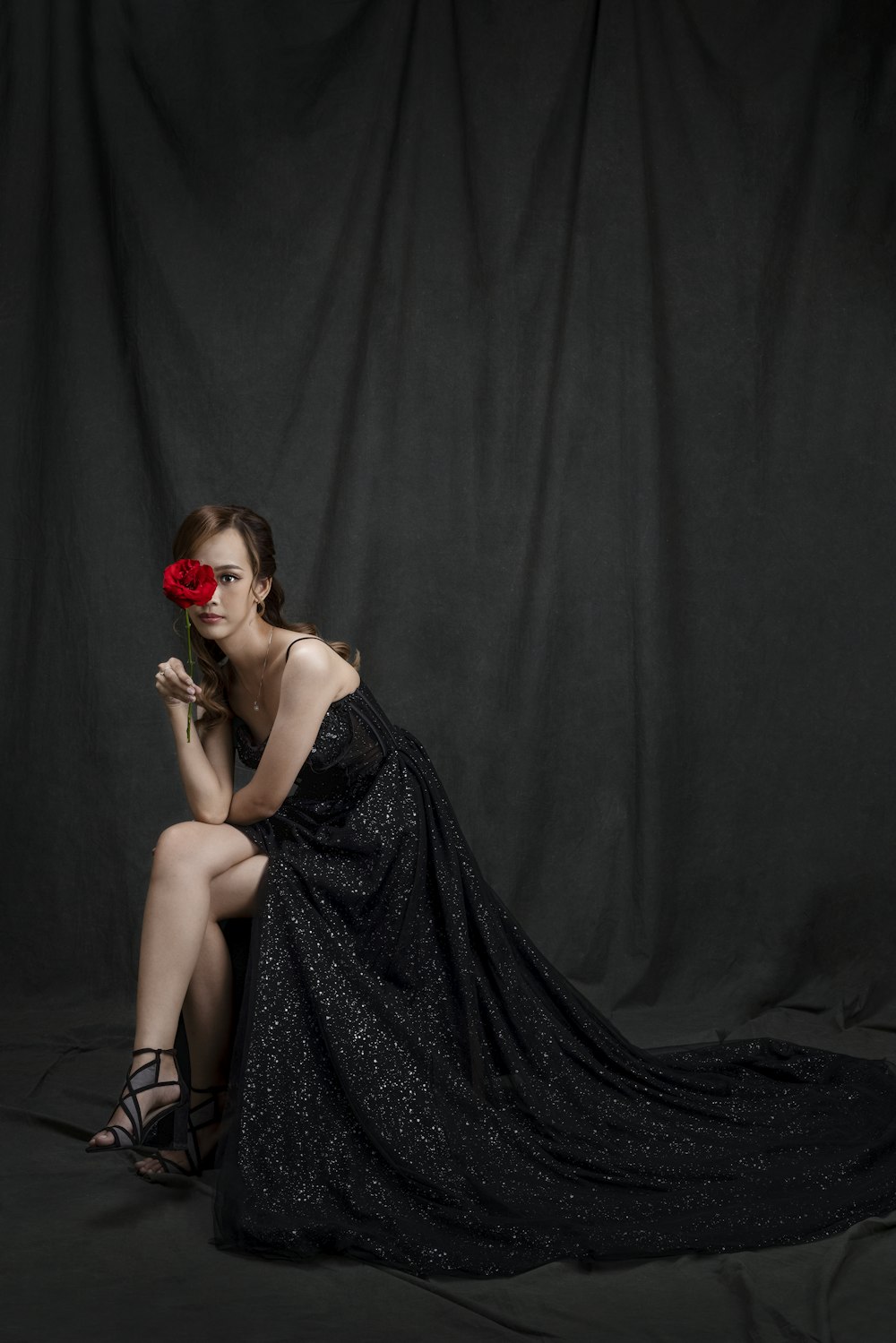 a woman in a black dress and a red rose