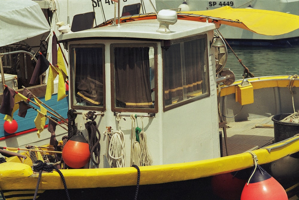 a yellow and white boat sitting in the water