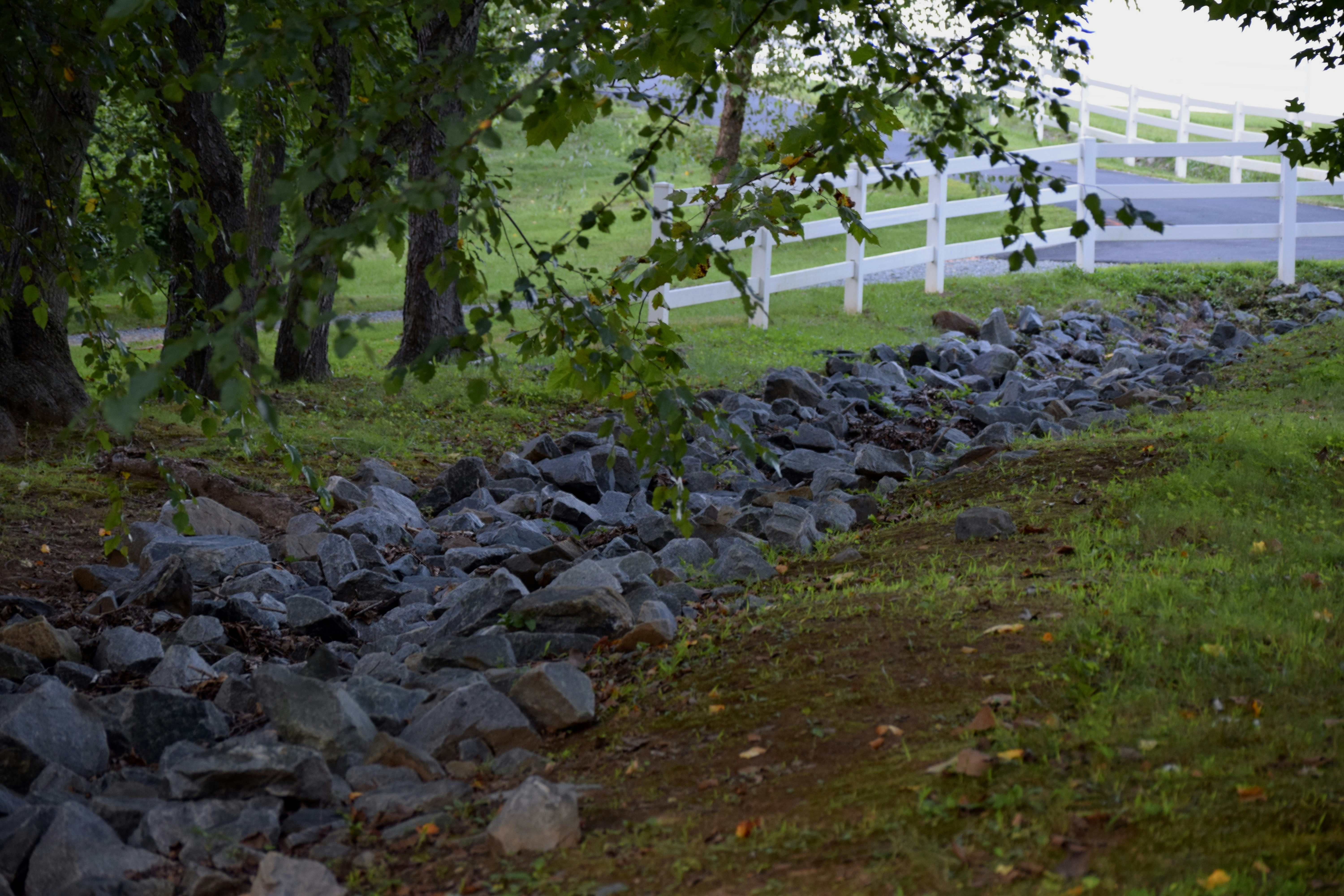 a white fence sitting next to a lush green field