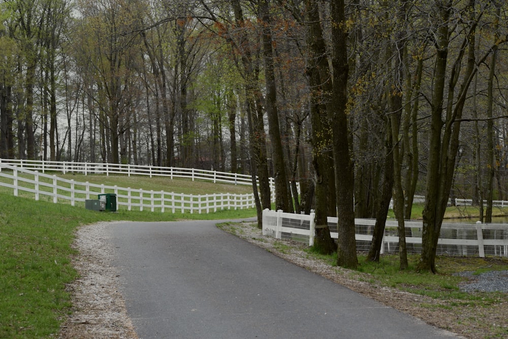 a white fenced in area next to a road