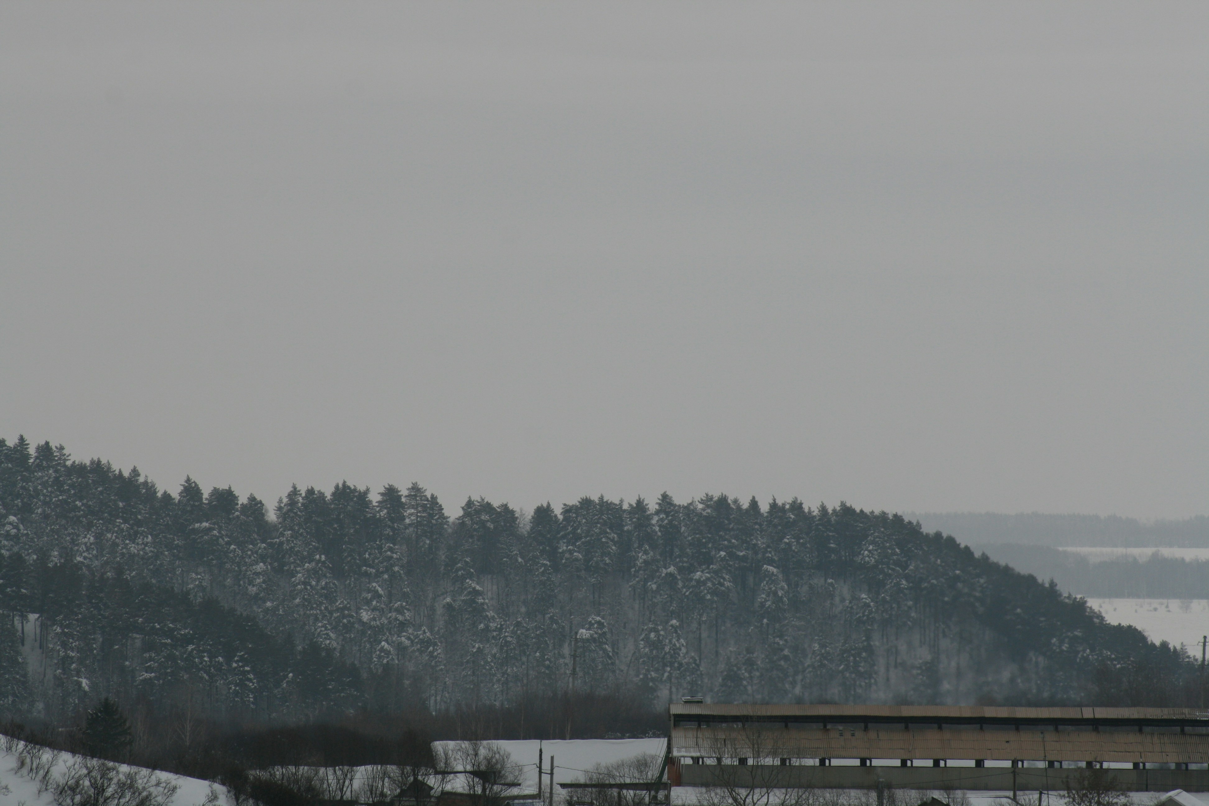 a view of a snow covered mountain with a building in the foreground