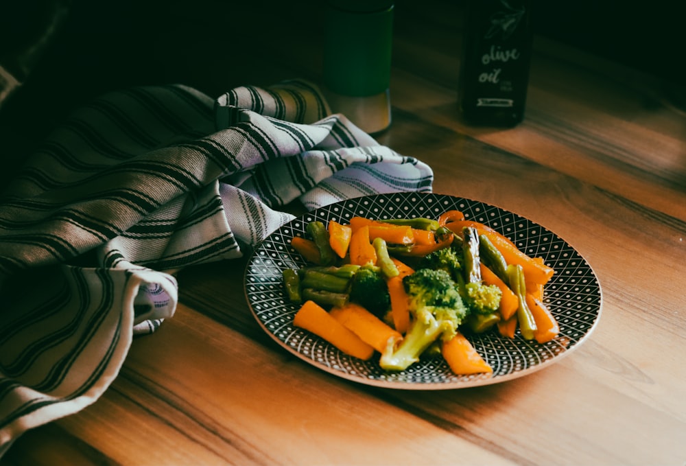 a plate of broccoli and carrots on a table