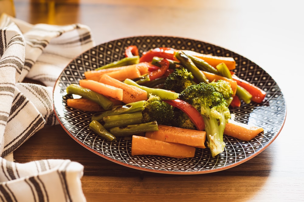 a plate of broccoli and carrots on a table