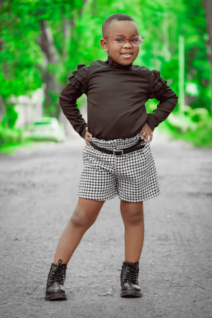 A confident 12-year-old girl posing in a stylish outdoor urban setting, wearing a chic, vogue-inspired outfit.