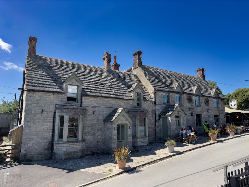 a stone building with a few people sitting outside of it