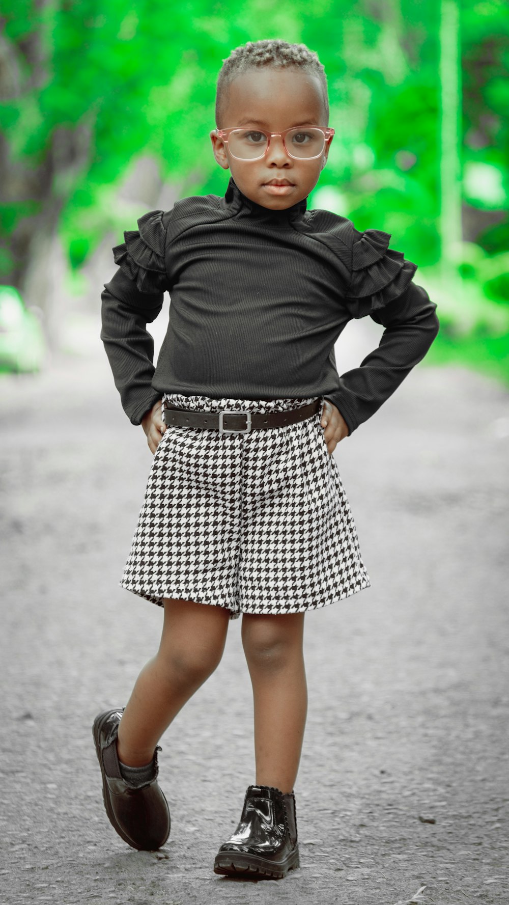 a little girl wearing glasses and a skirt