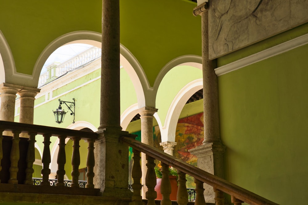 a green building with arches and a staircase
