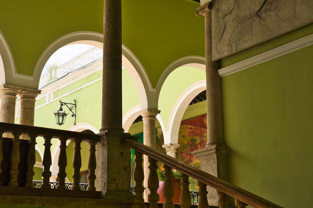 un bâtiment vert avec des arches et un escalier