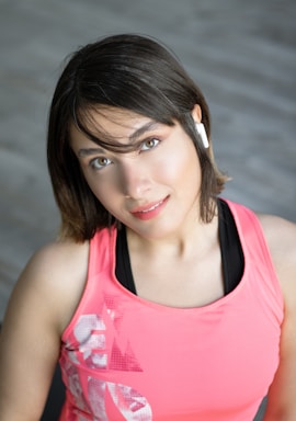 A friendly customer support representative wearing a headset with fitness gear in the background.