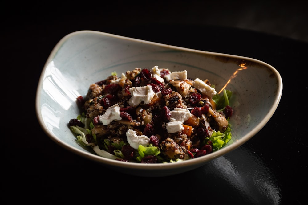 a white bowl filled with a salad topped with feta cheese