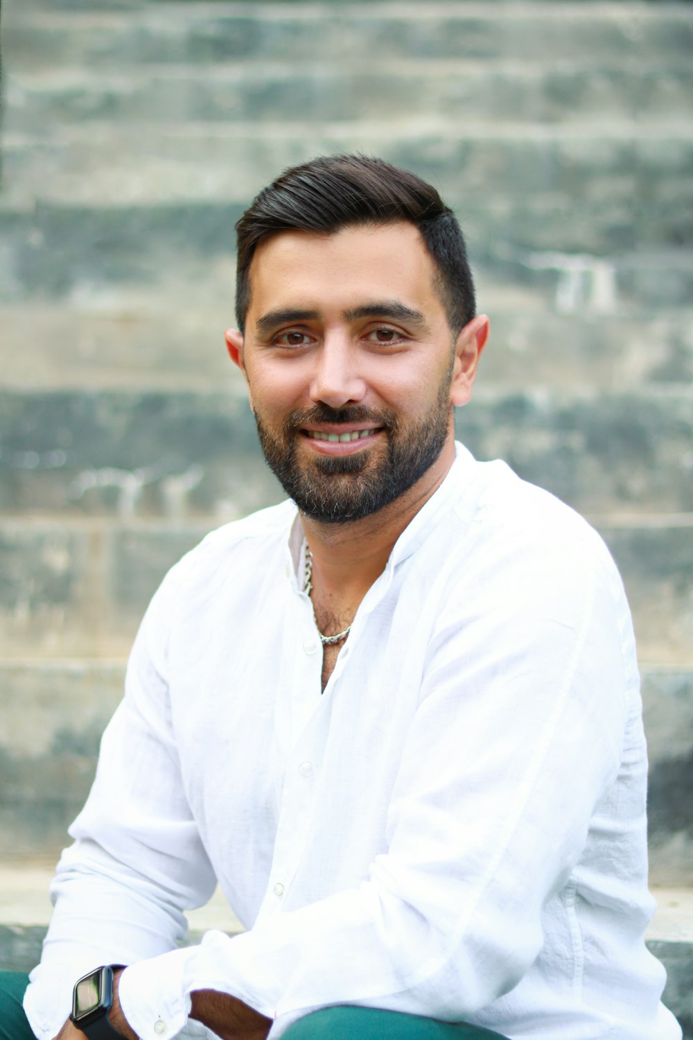 a man with a beard sitting on some steps