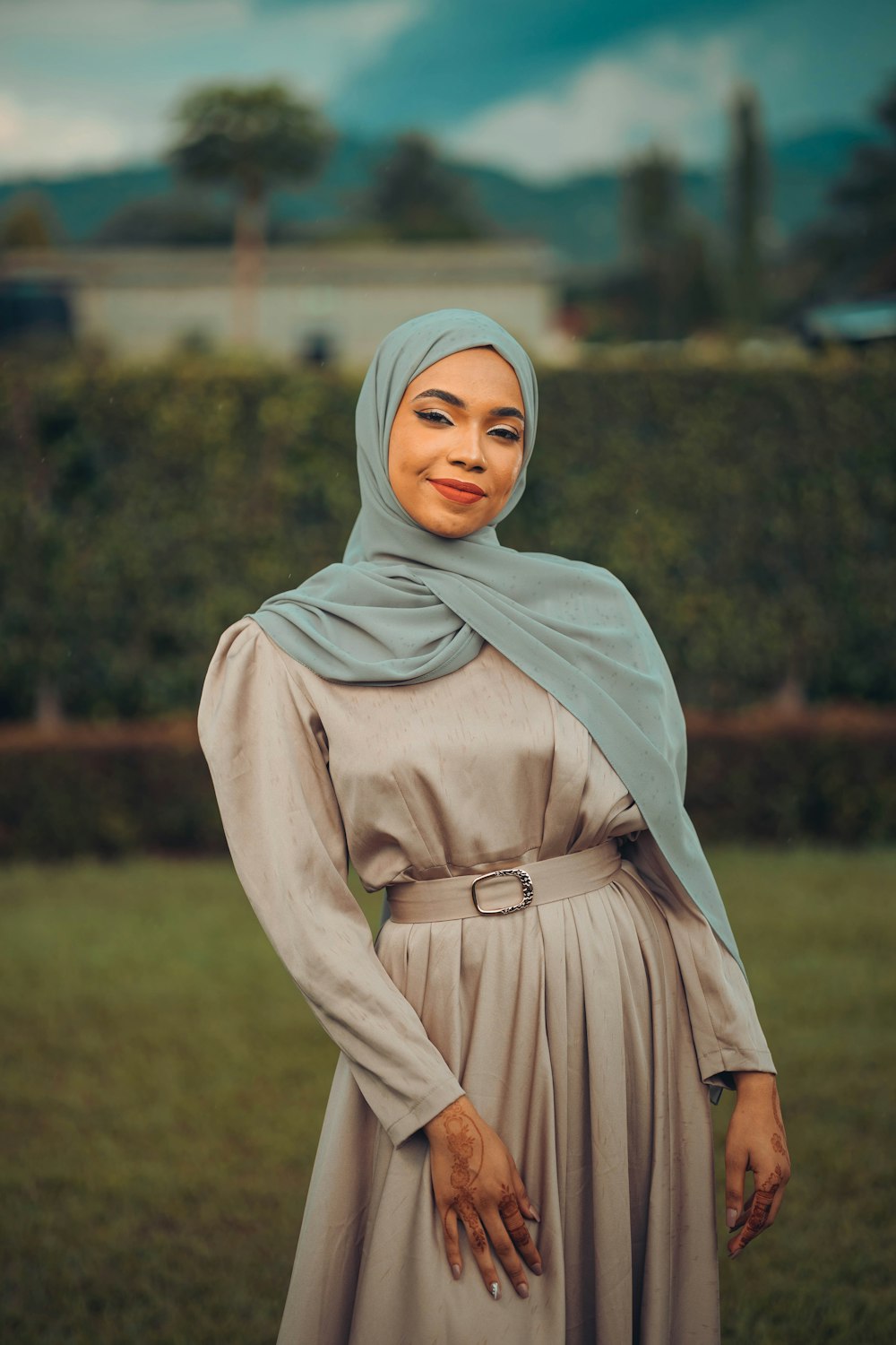 a woman wearing a hijab standing in a field