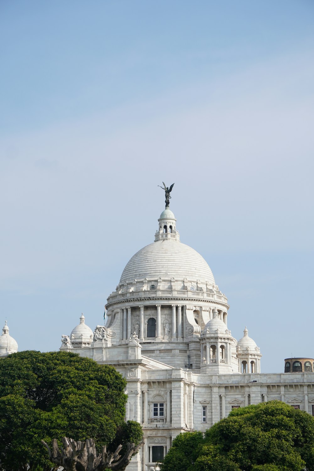 un grande edificio bianco con una statua sopra di esso