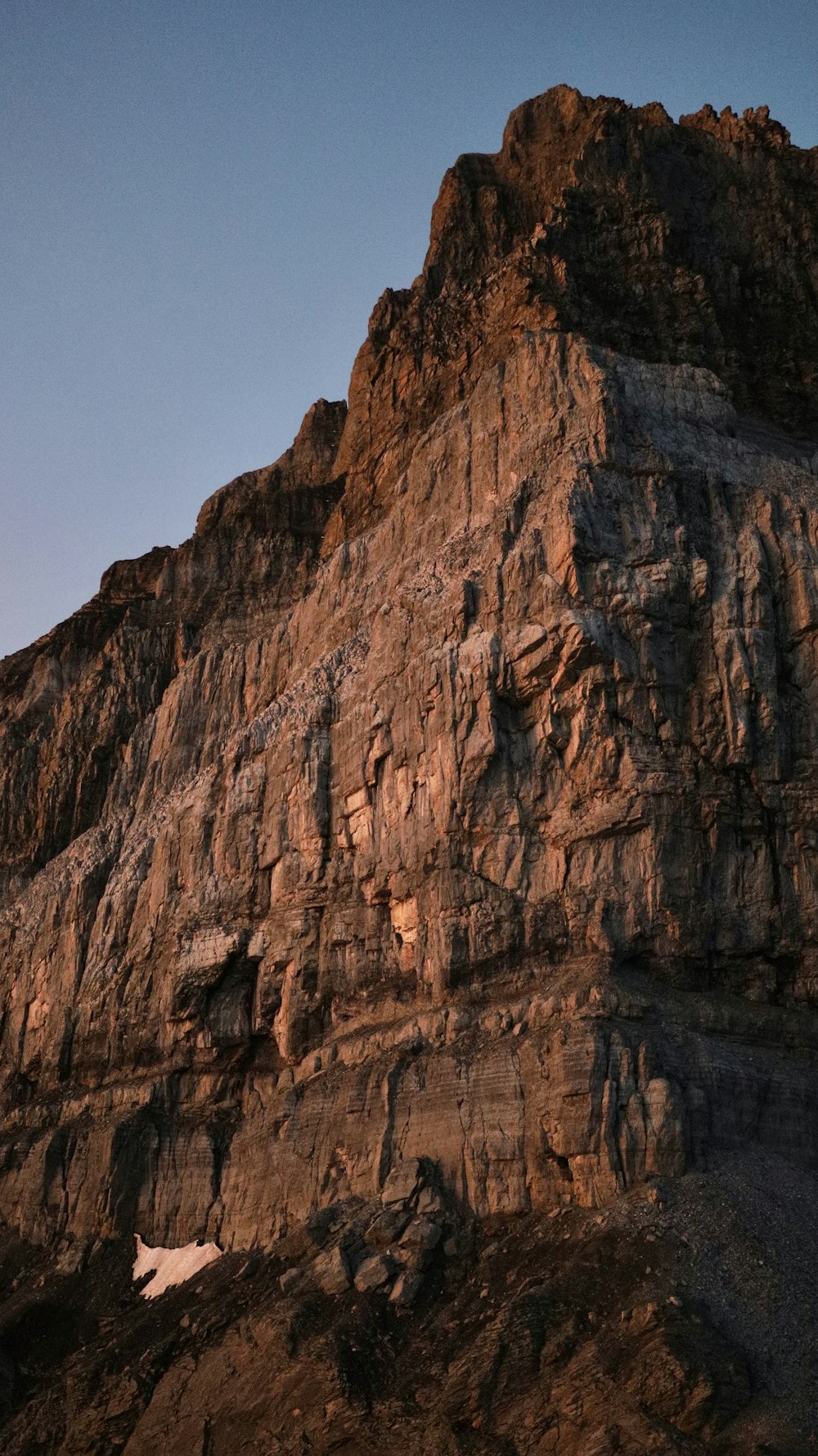 a large mountain with a very tall rock face