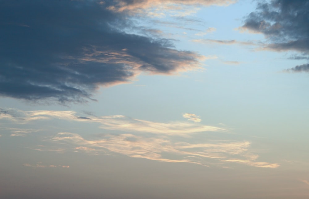 a plane is flying in the sky with clouds