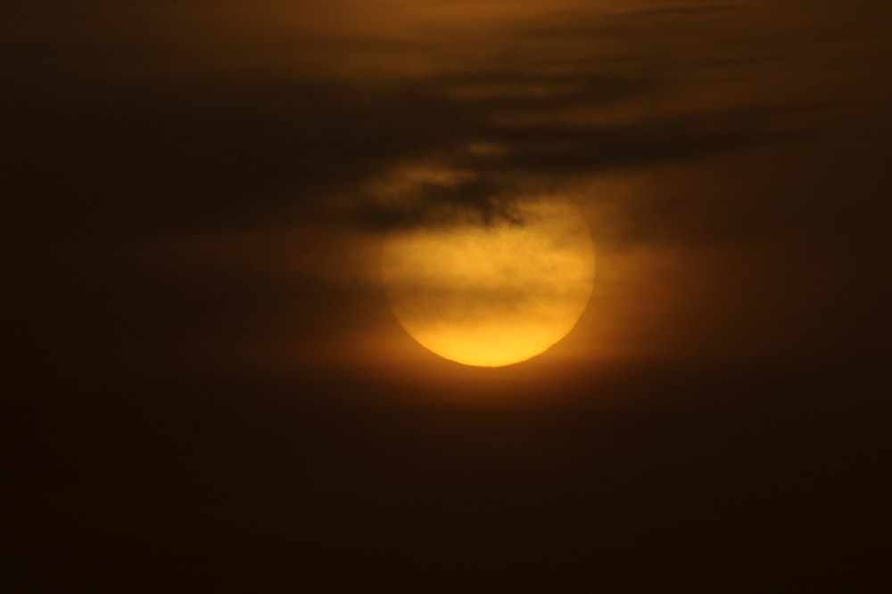 the sun is setting behind a cloud in the sky