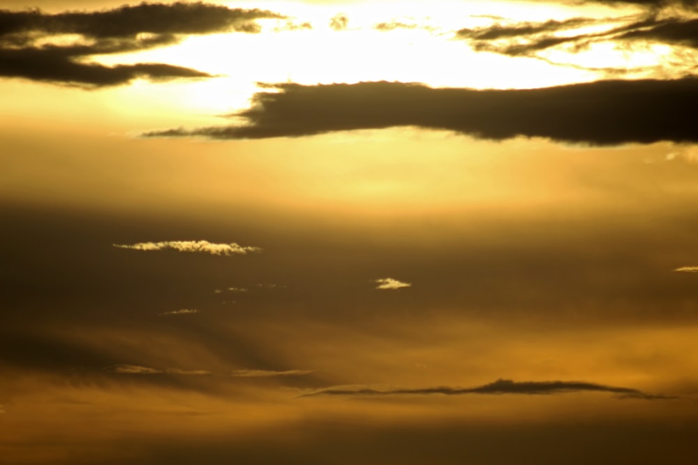 a plane flying in the sky at sunset