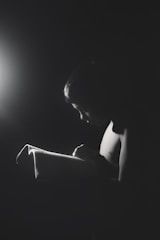 A young girl reading a book in a brightly lit classroom.
