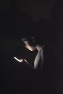 Close-up of a business professional reviewing a glowing contact database on a dark screen.